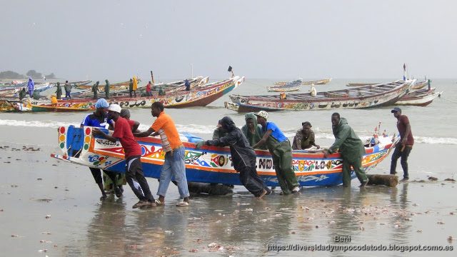 Gambia playa Tanji pescadores empujando barco